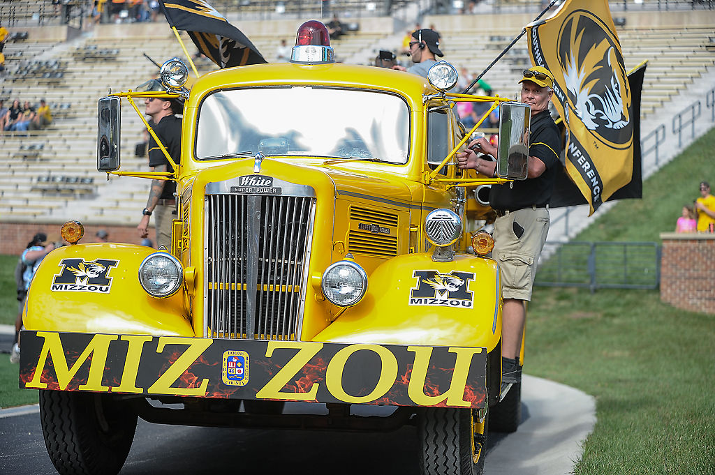 A big yellow Mizzou fire truck zooms by the north end zone